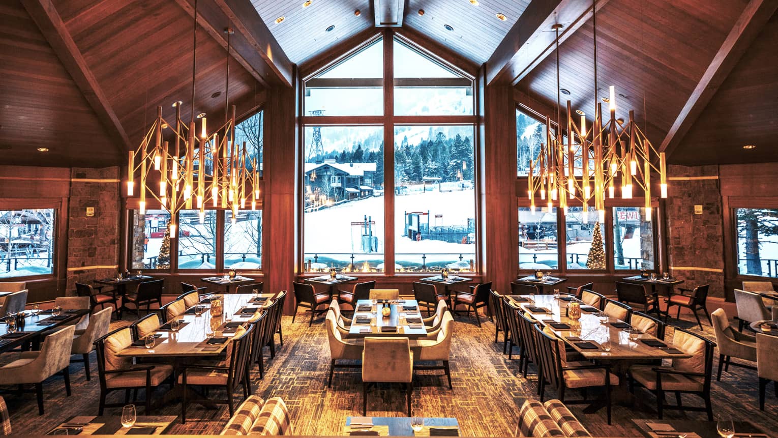 The spacious Westbank Grill dining room revealing ample seating, large windows, and mountainous surroundings.