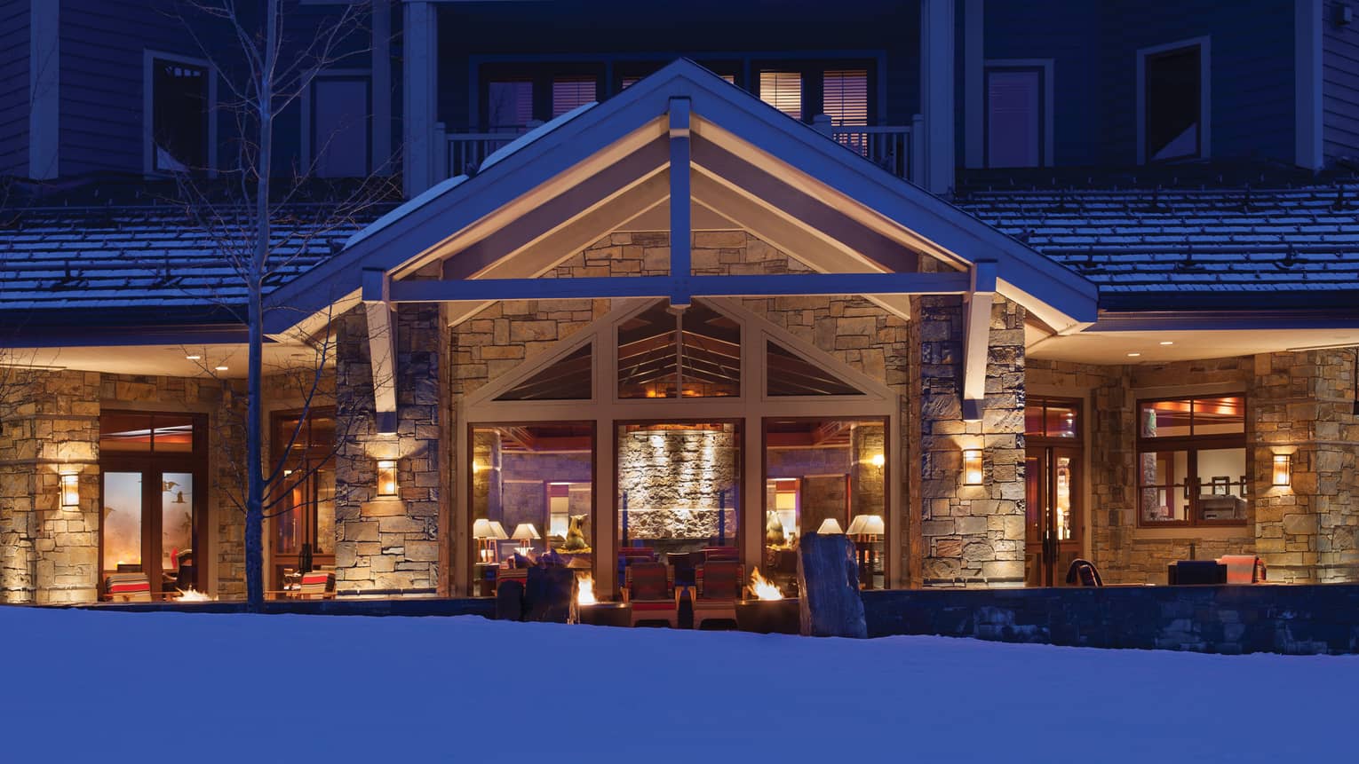 The entrance to the hotel at dusk, the interior aglow with lamplight 