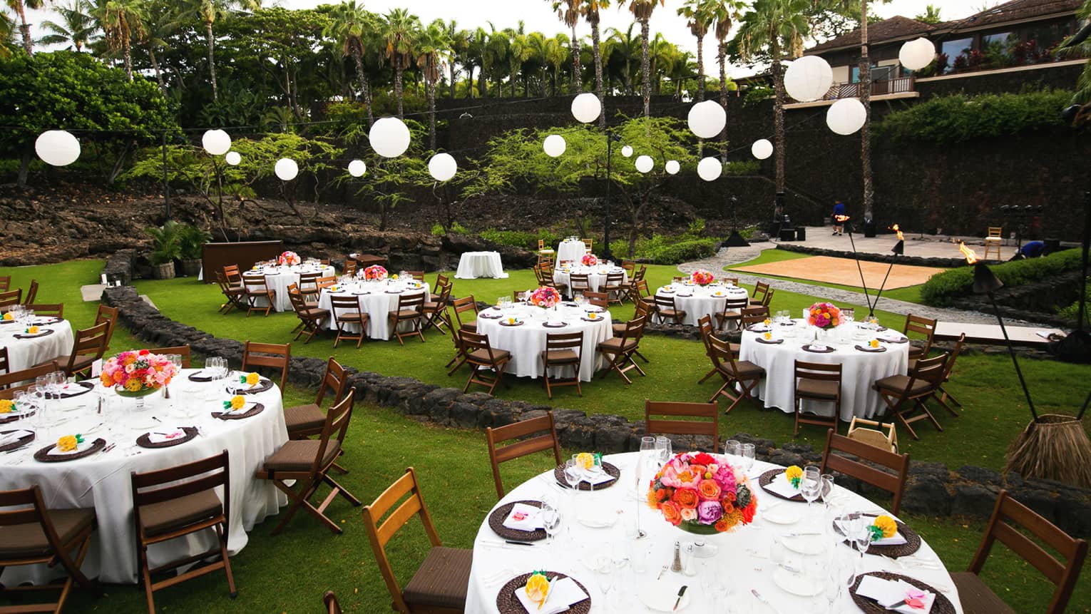 Daytime garden wedding with round banquet tables under globe lanterns