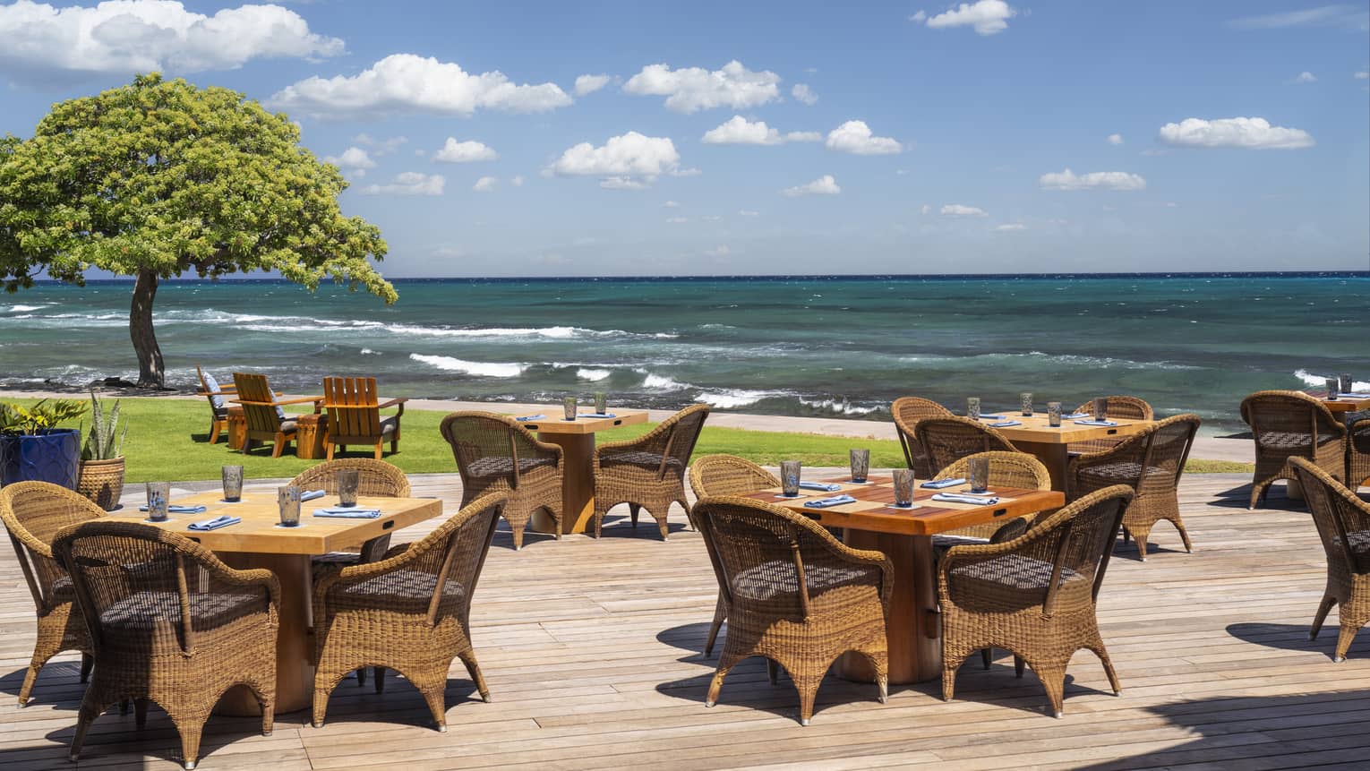 Restaurant wooden terrace with tables next to the ocean