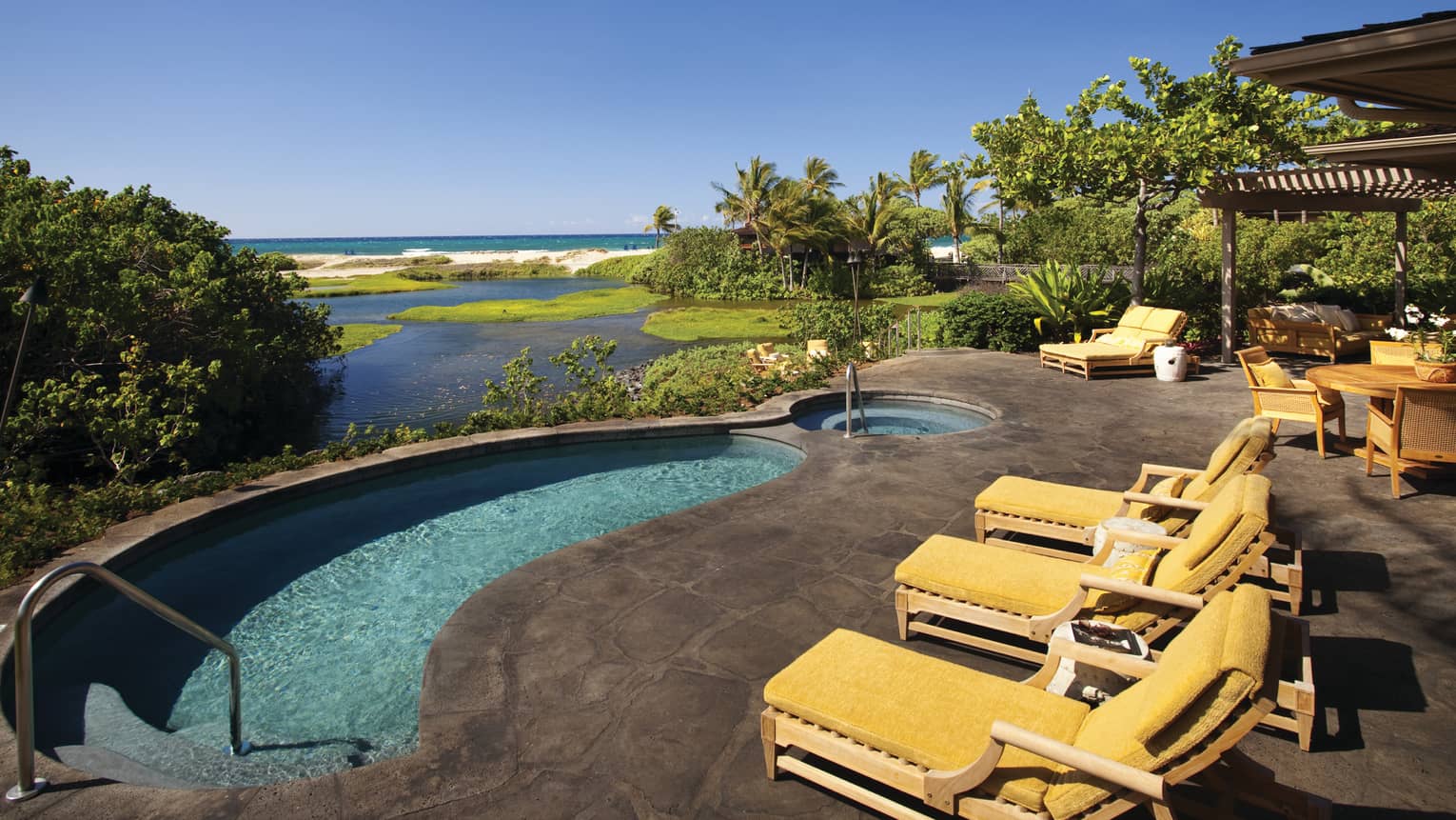 Makaloa Villa yellow patio chairs by curved plunge pool overlooking ocean, beach
