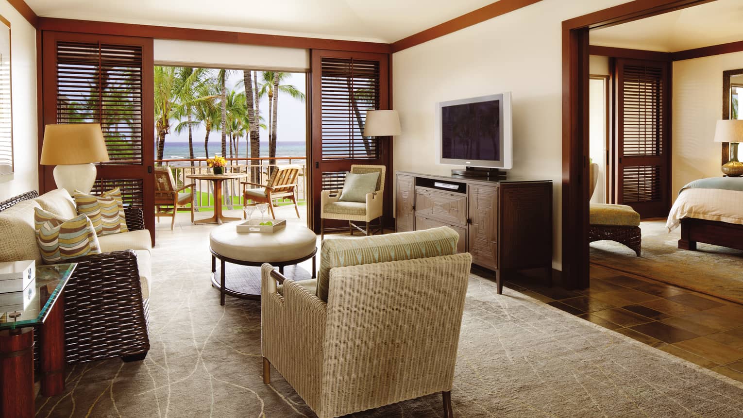 Superior Suite wicker sofa, armchair across from dresser TV by bedroom and patio doors