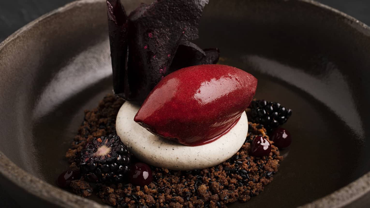 Black sesame and chocolate crumble, black sesame mousse, and blackberry-and-lemongrass sorbet served in a dark-brown bowl