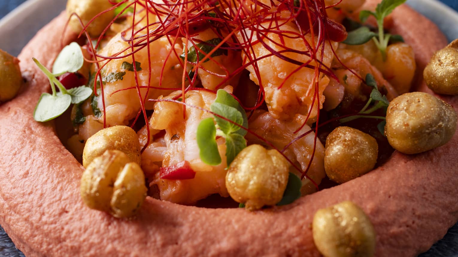 Red-hued hummus served with pepper marmalade, mild chili and prawns