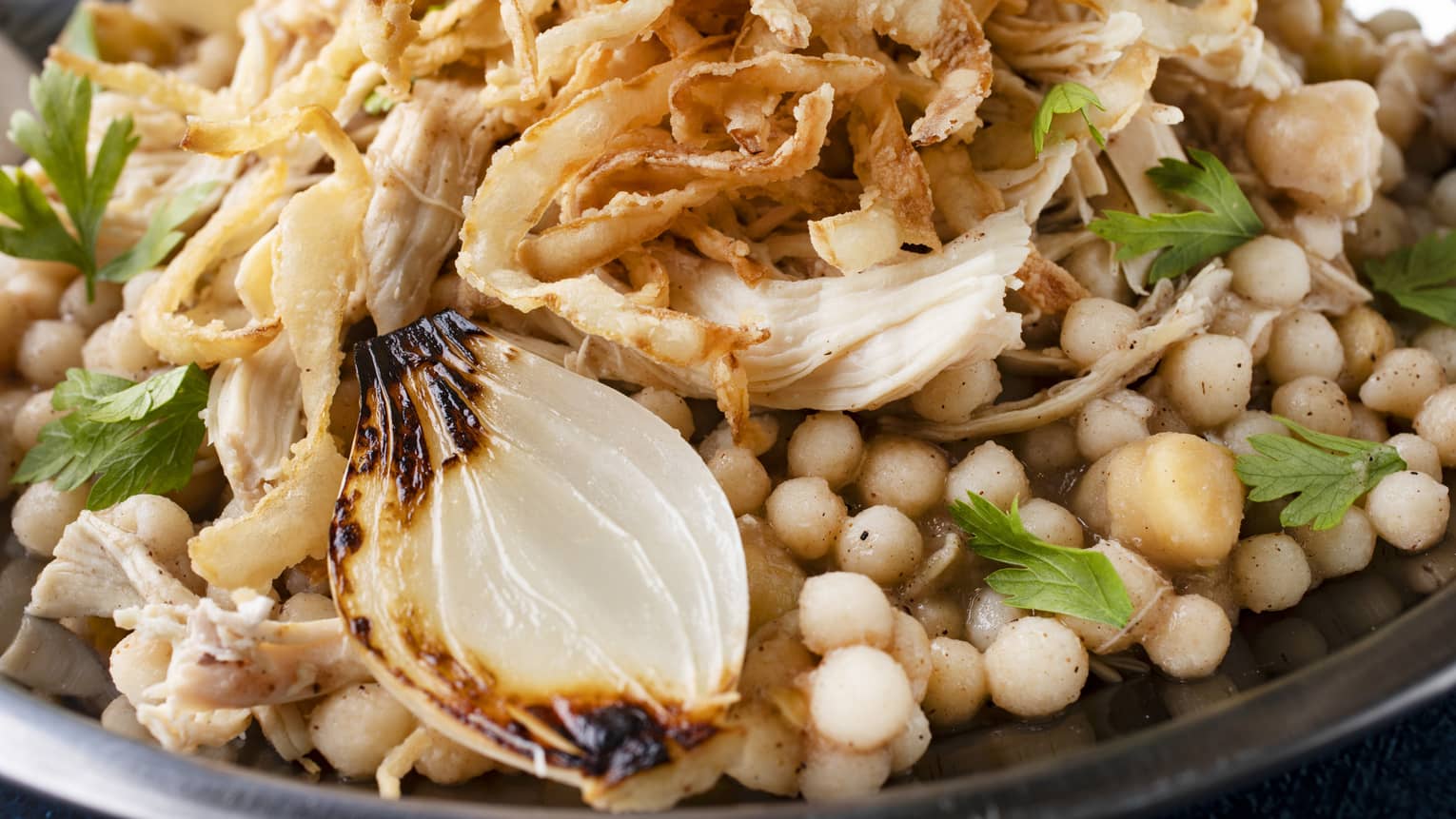 Moghrabieh pearls, shredded chicken, crispy onions and gravy sauce served on a silver platter
