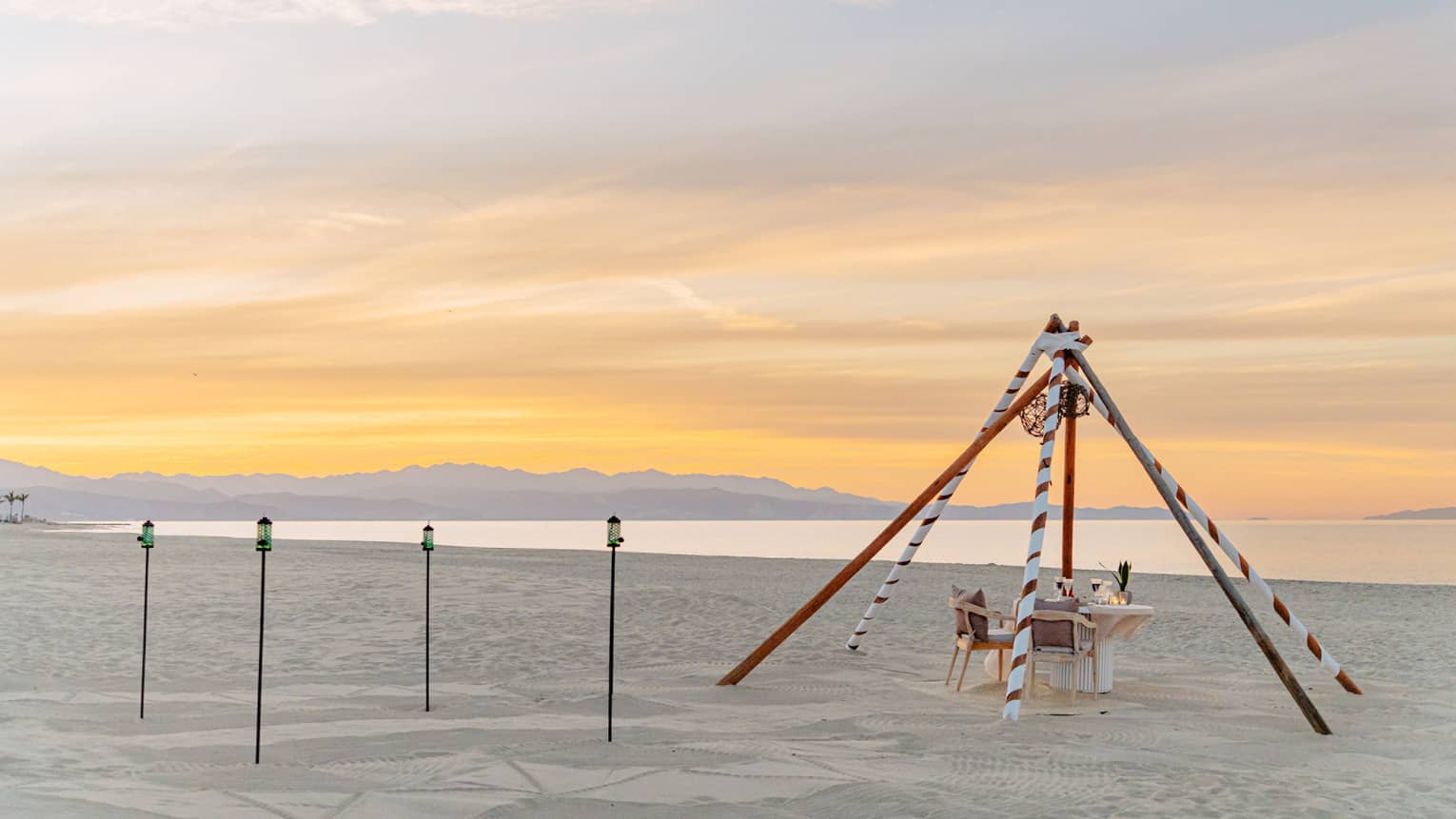 Dining table on the beach at sunset