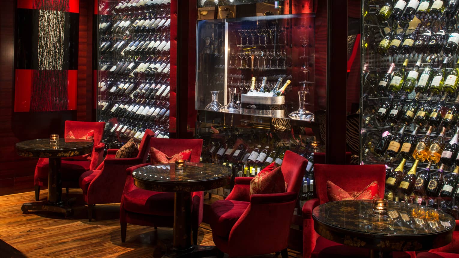Amaranto Bar red velvet lounge chairs, large glass cellars with bottles, Champagne ice bucket