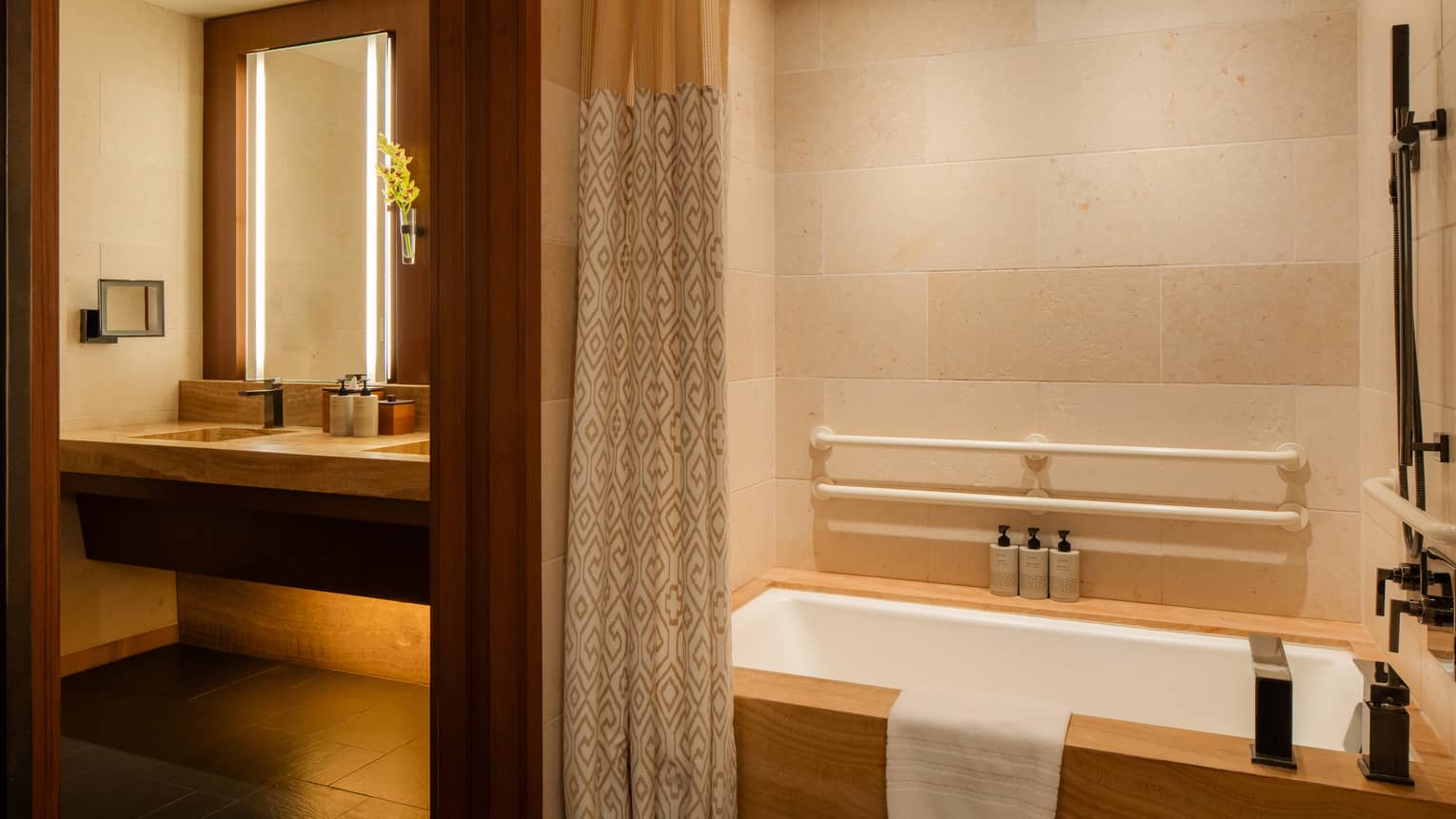 Accessible bathroom featuring a low tub with grab bars