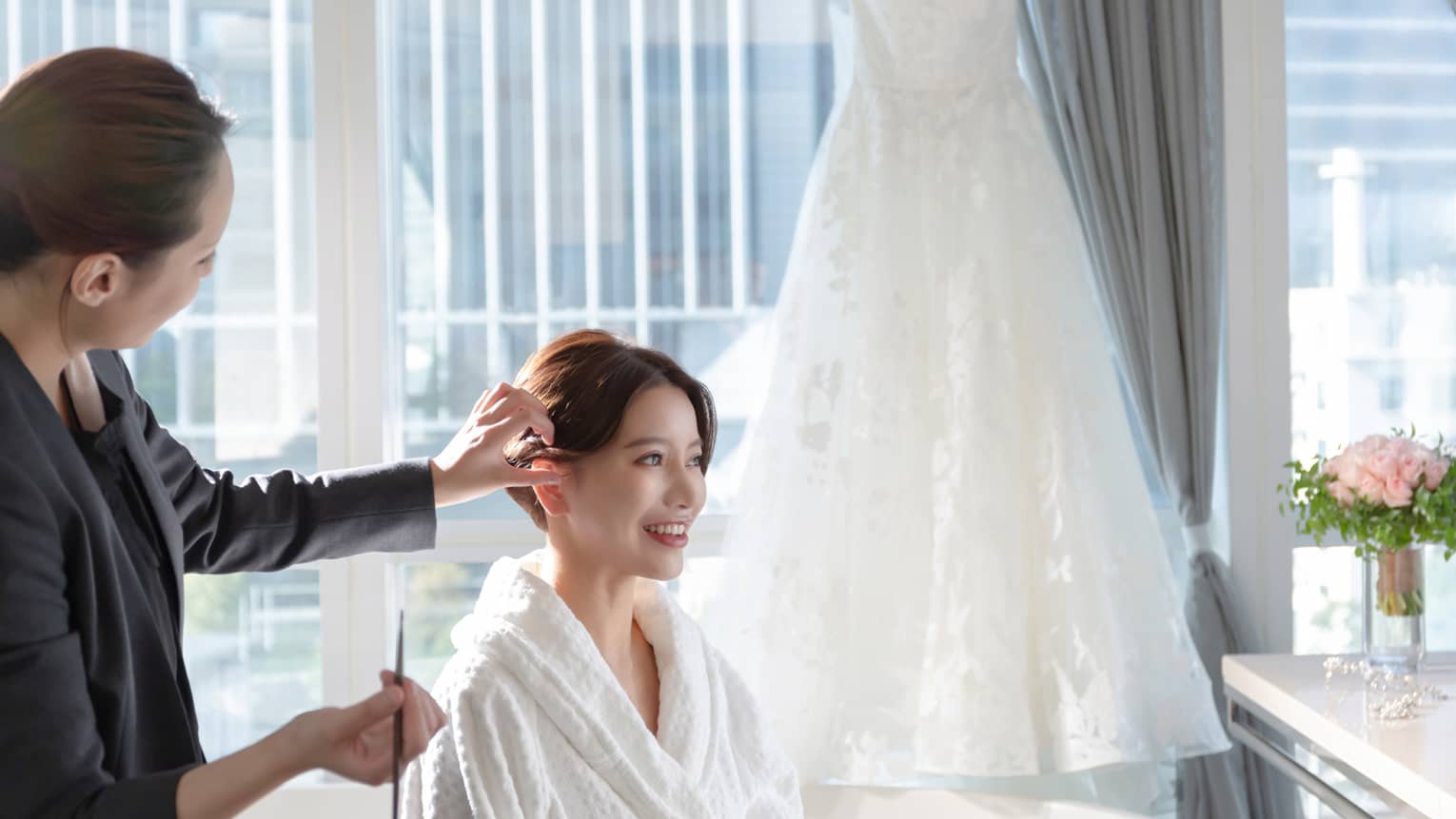 Woman gets hair done for wedding in luxury hotel room