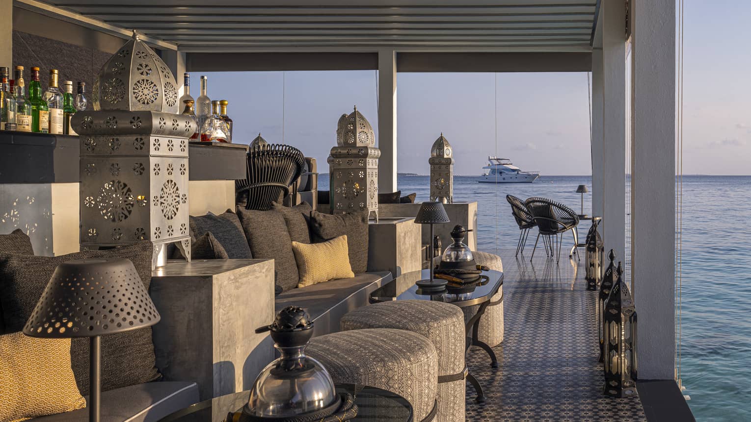 Covered seaside bar at Shisha Bar, catamaran in background