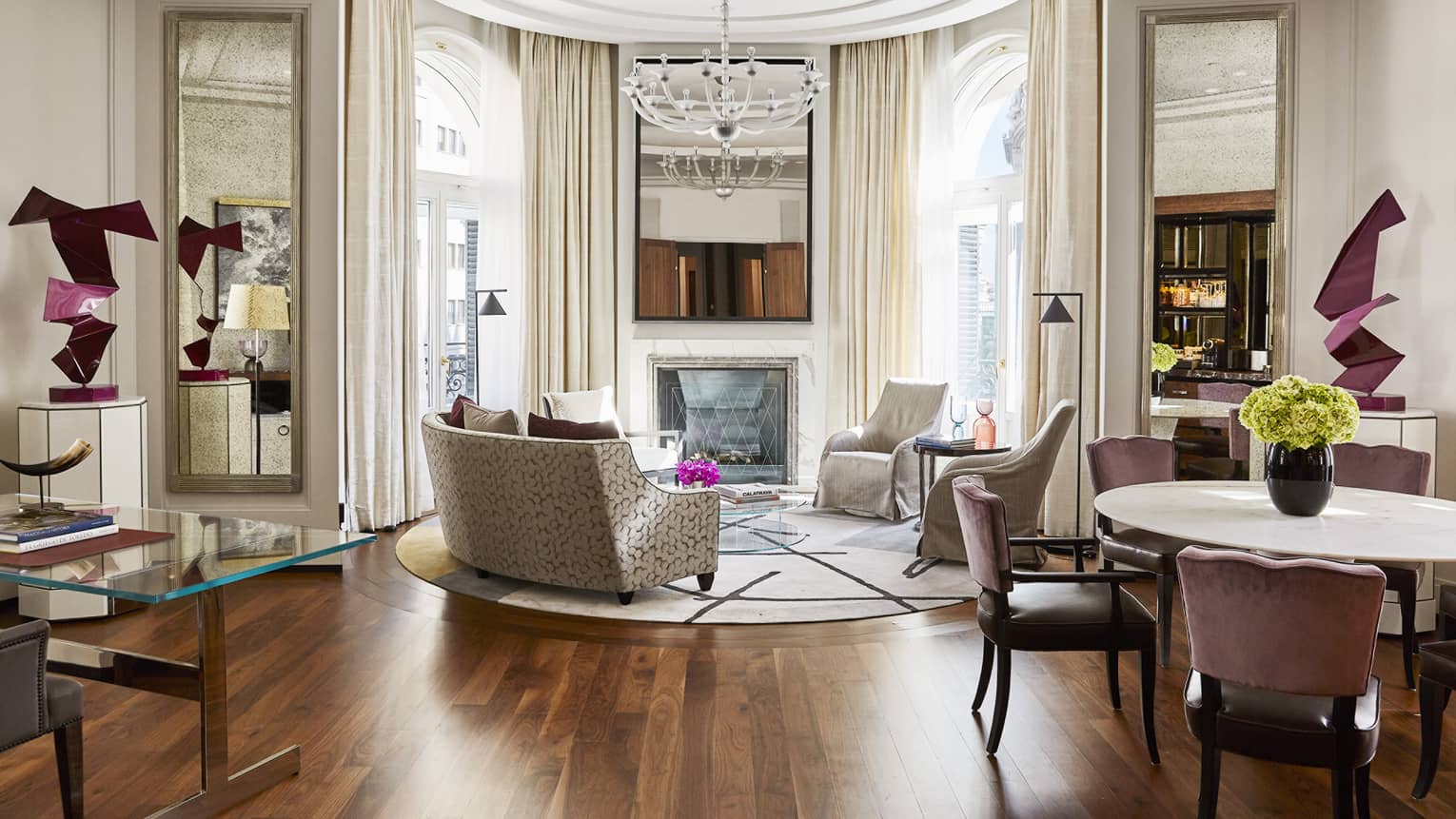 Circular living room, white crown molding, sofa and two arm chairs, chandelier