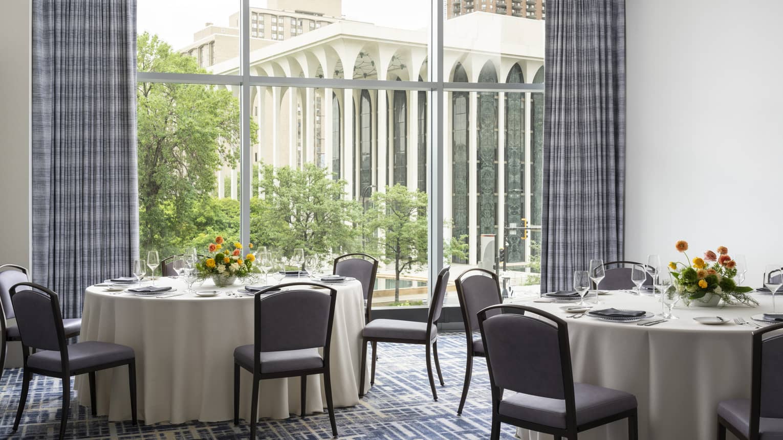 A meeting room with round tables and a large window.