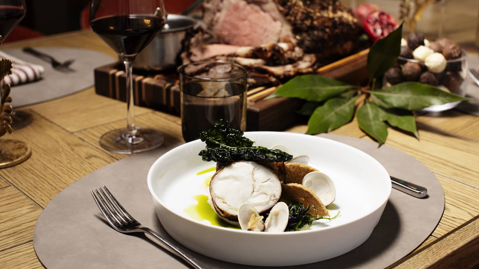 Set table for dinner with standing rib roast and wine glasses