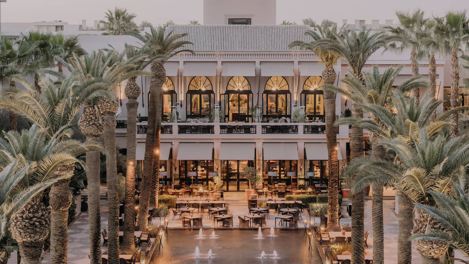 Exterior of property with outdoor dining setup surrounded by leafy palm trees