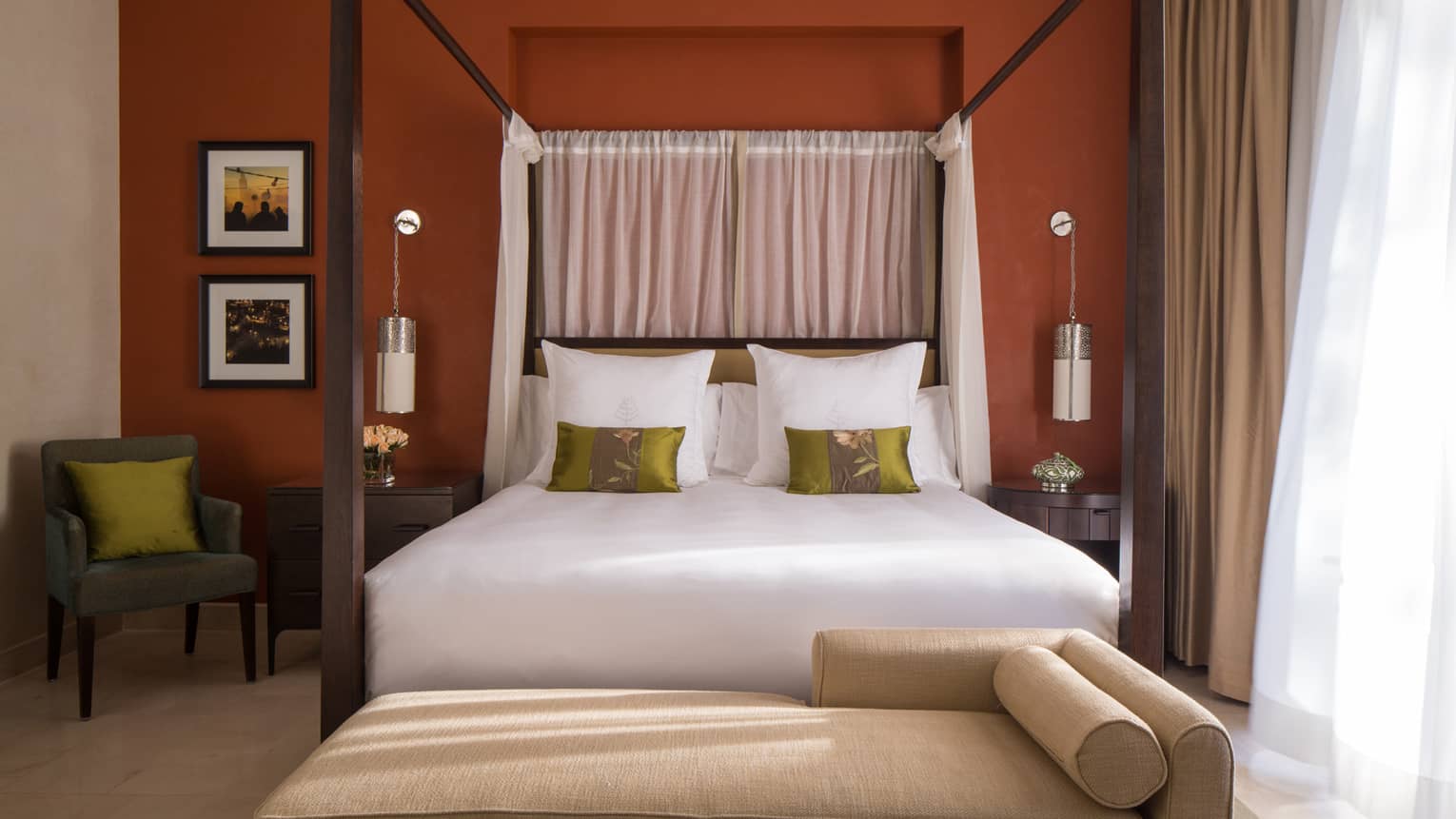 Premier Patio Suite with Private Pool chaise, poster bed with accent pillows against burgundy wall with modern armchair, framed photos