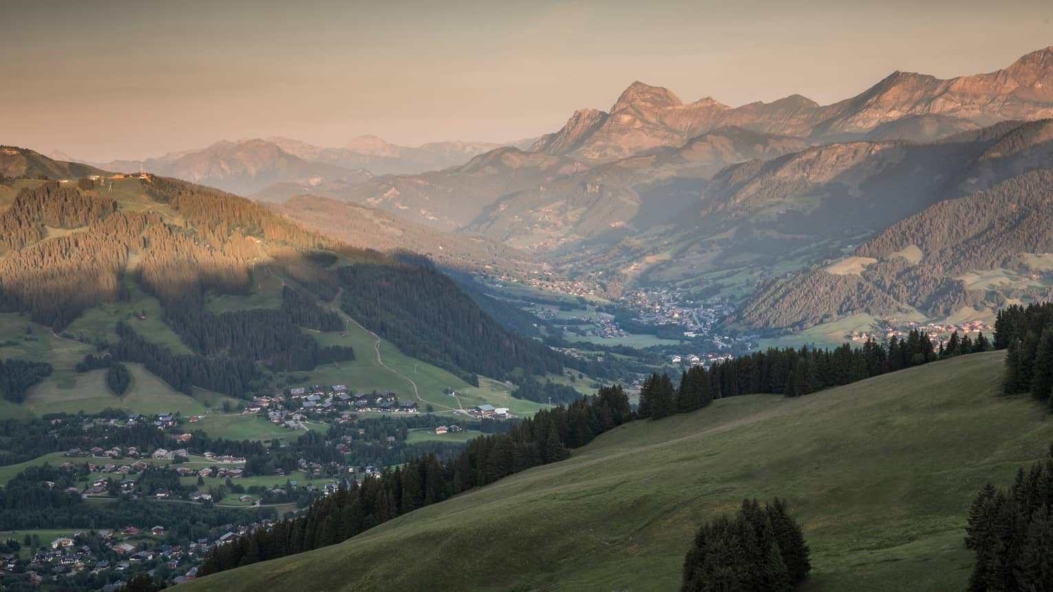 Sweeping views over green French Alps mountains at sunset 