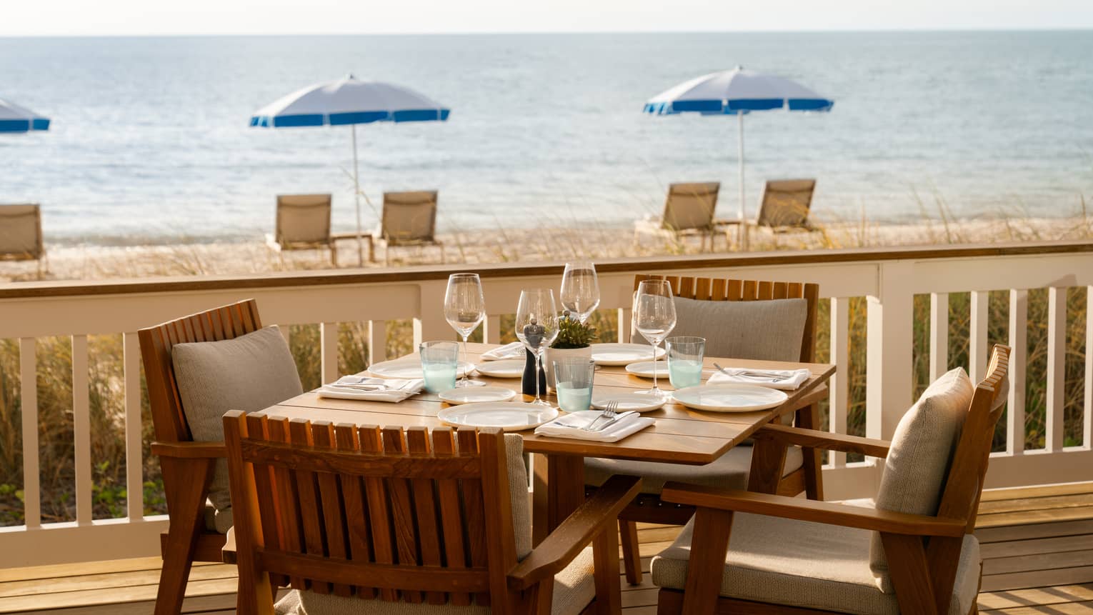Table for four set on an outdoor terrace overlooking the beach