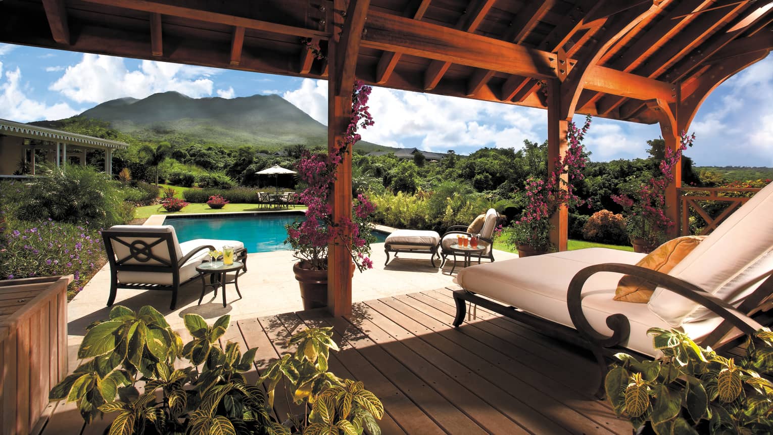 Residence Villa plush lounge chair on wood covered patio by outdoor swimming pool