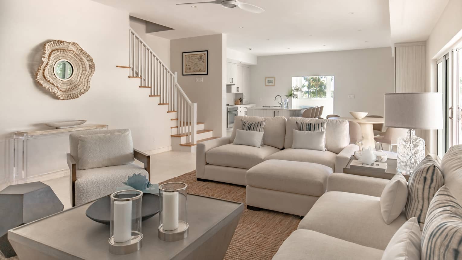 Living room with white sofas and arm chair, white walls and wooden floors