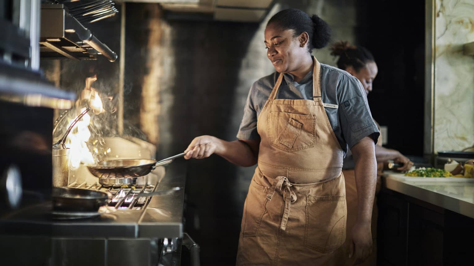 This image depicts a person cooking at the Four Seasons Resort Nevis, West Indies, home to many great ESG initiatives.