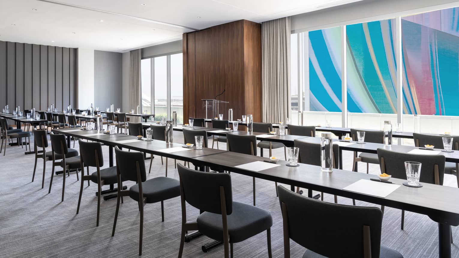 A large meeting room with long tables and large windows.