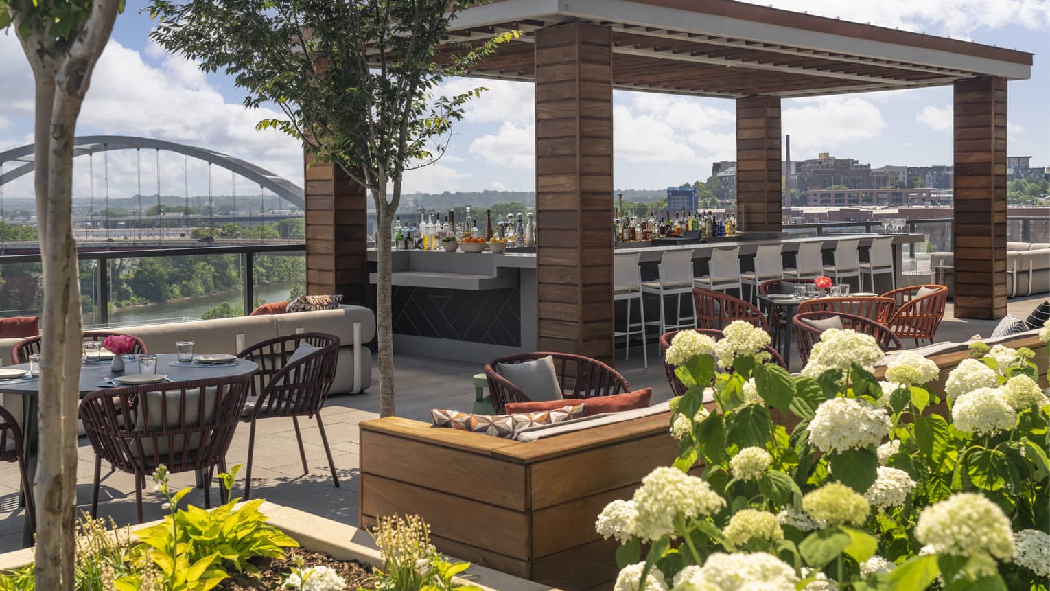 Rooftop terrace with a bar area and view of the city.