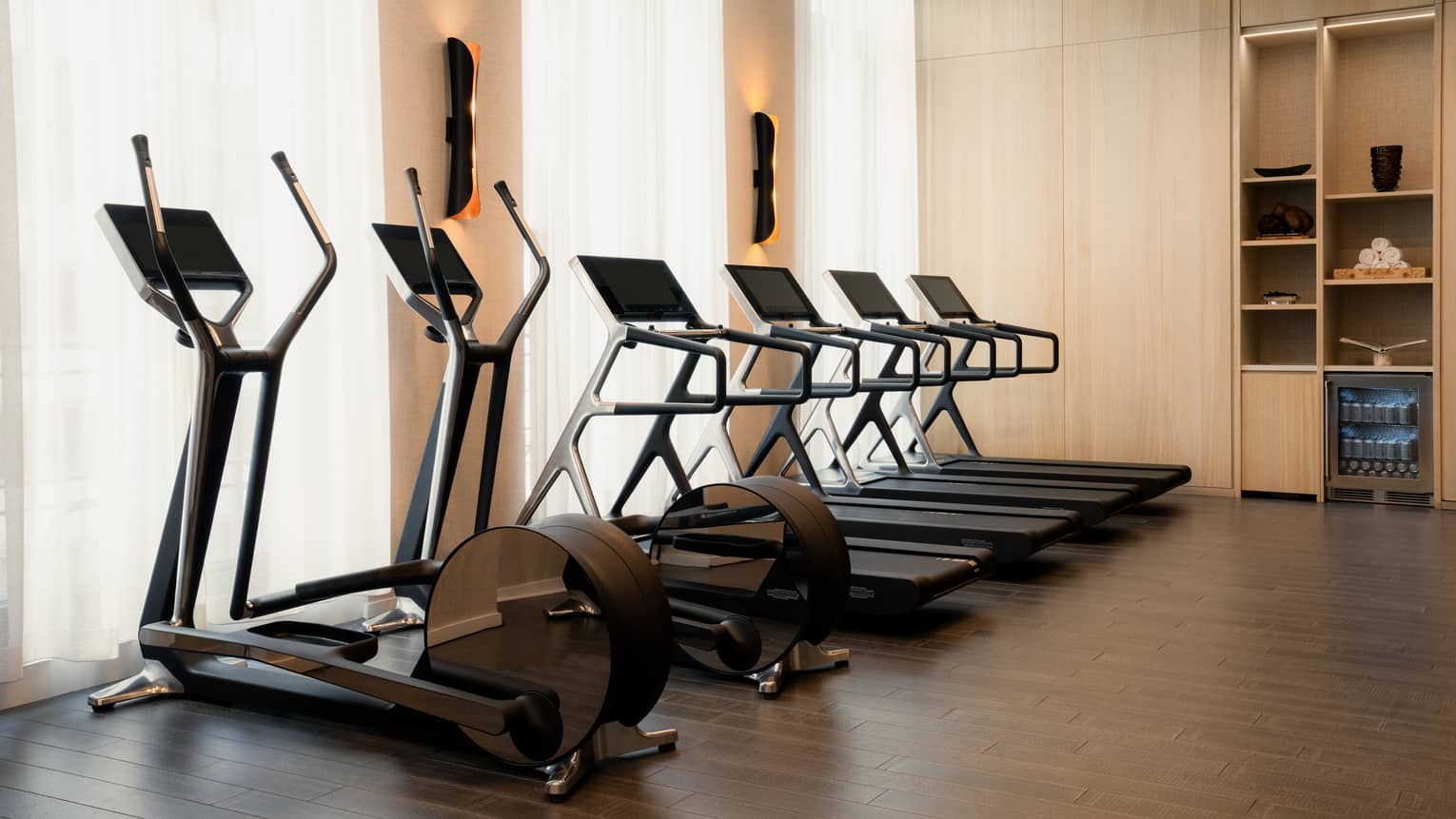 Exercise machines placed near three windows in the Fitness Centre