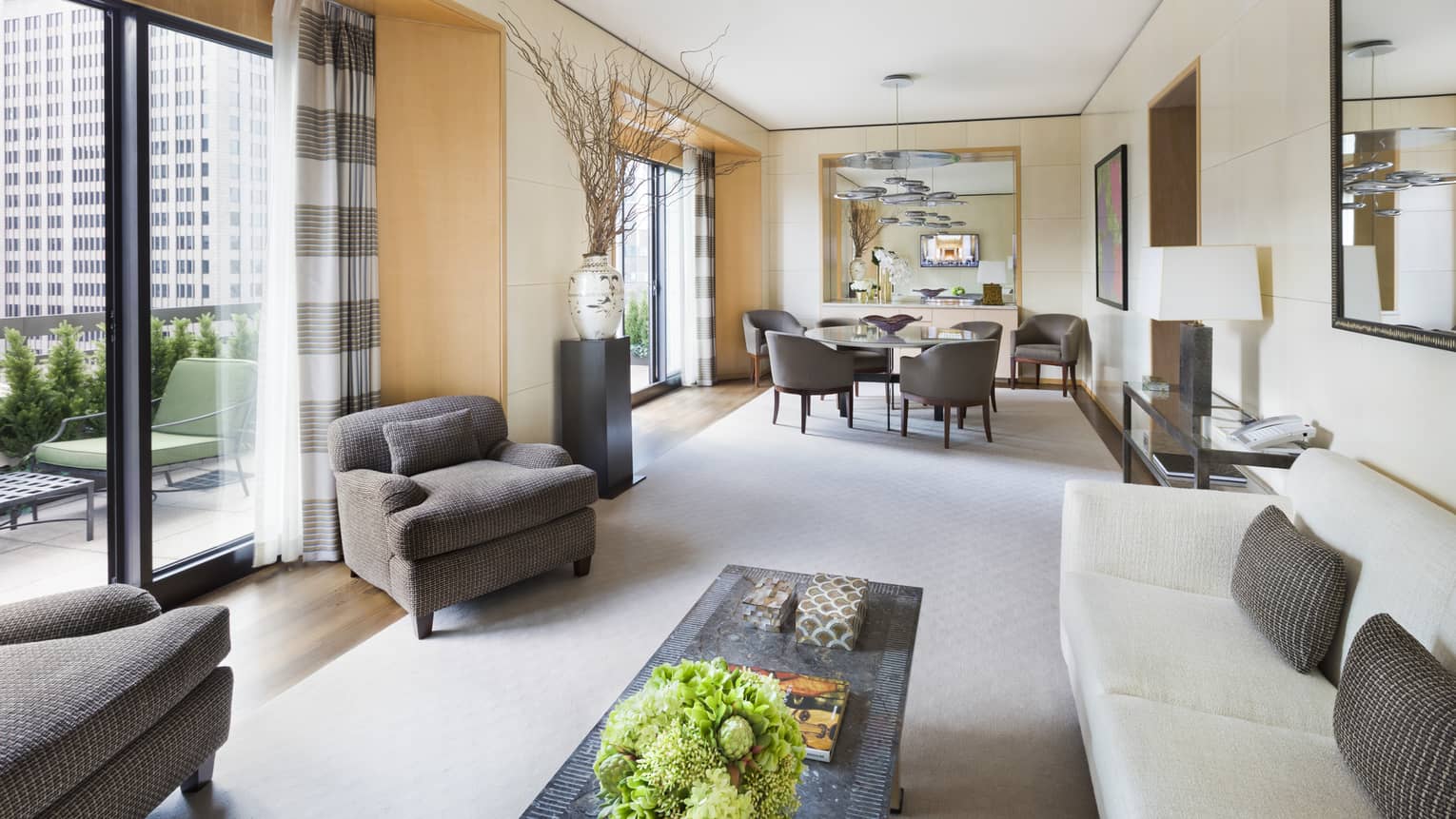 Bright, spacious Royal Suite seating and dining areas with double patio doors 