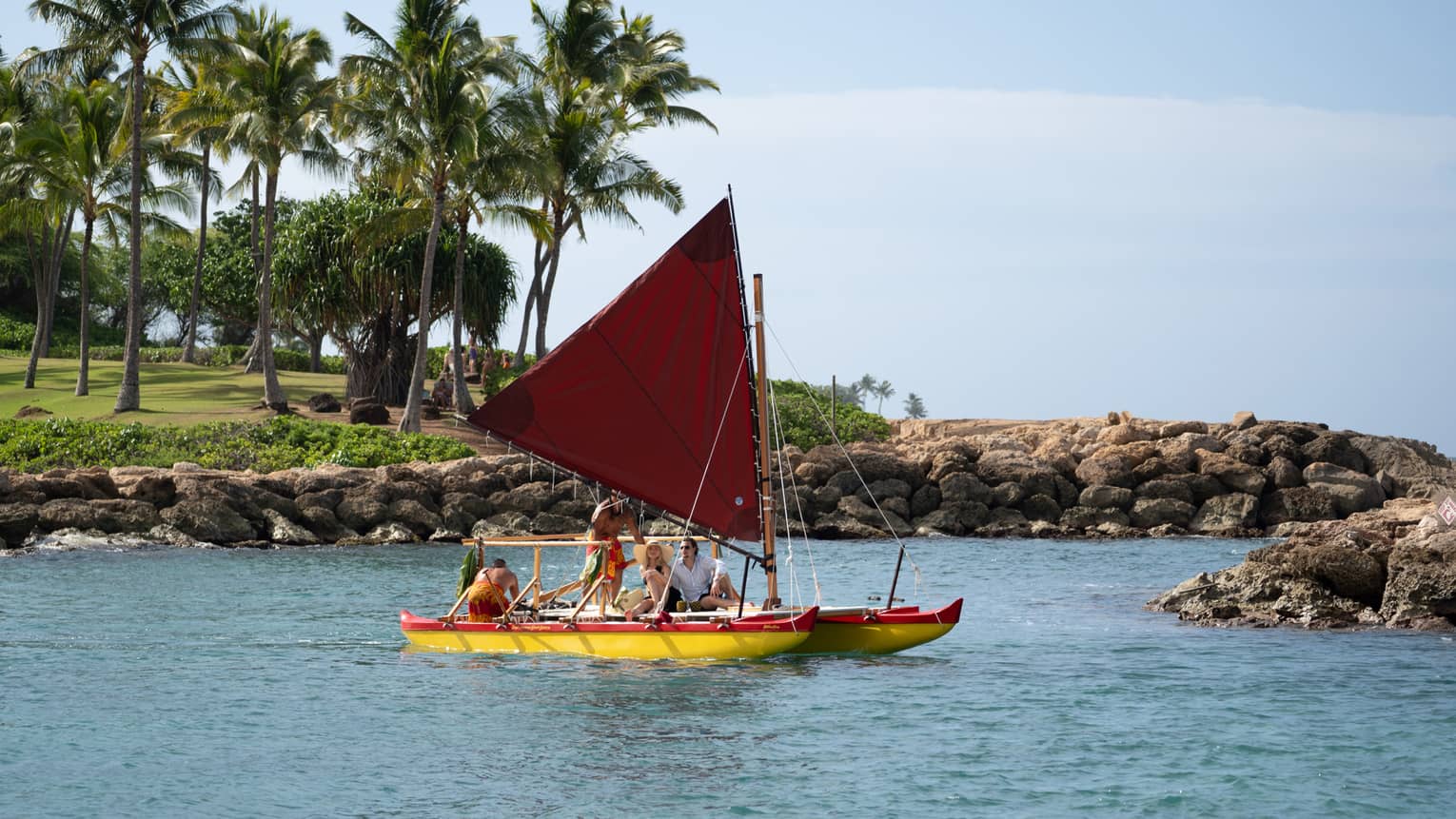 People sail in a traditional Hawaiian canoe in a lagoon
