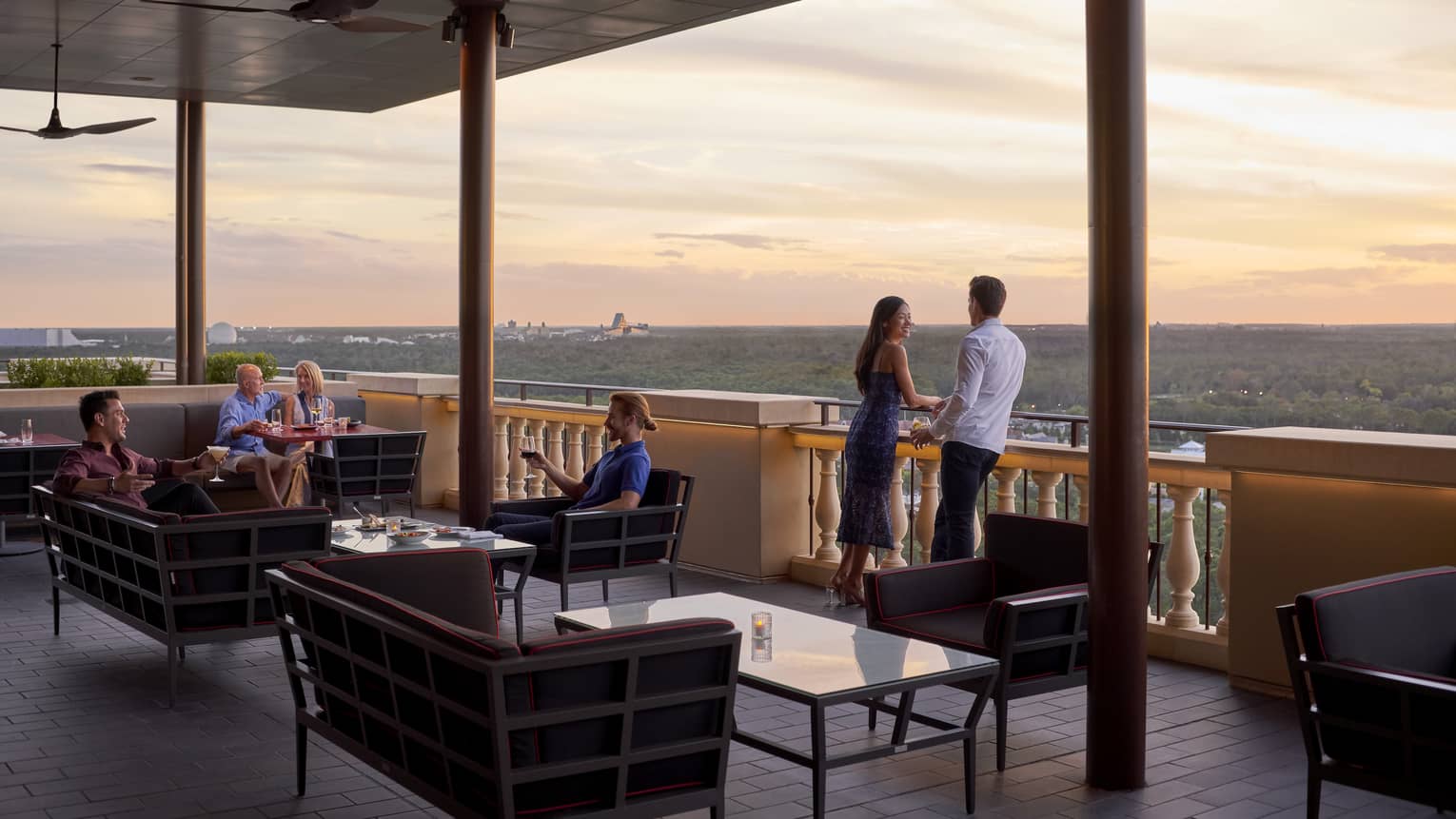 People lounge on Capa Bar terrace under roof at sunset
