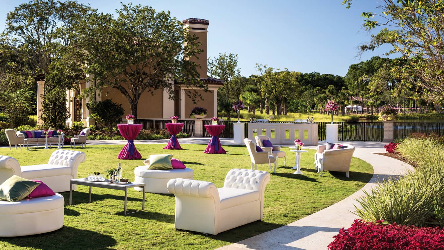 Modern white sofas, cocktail tables along path on sunny King Meadow event lawn