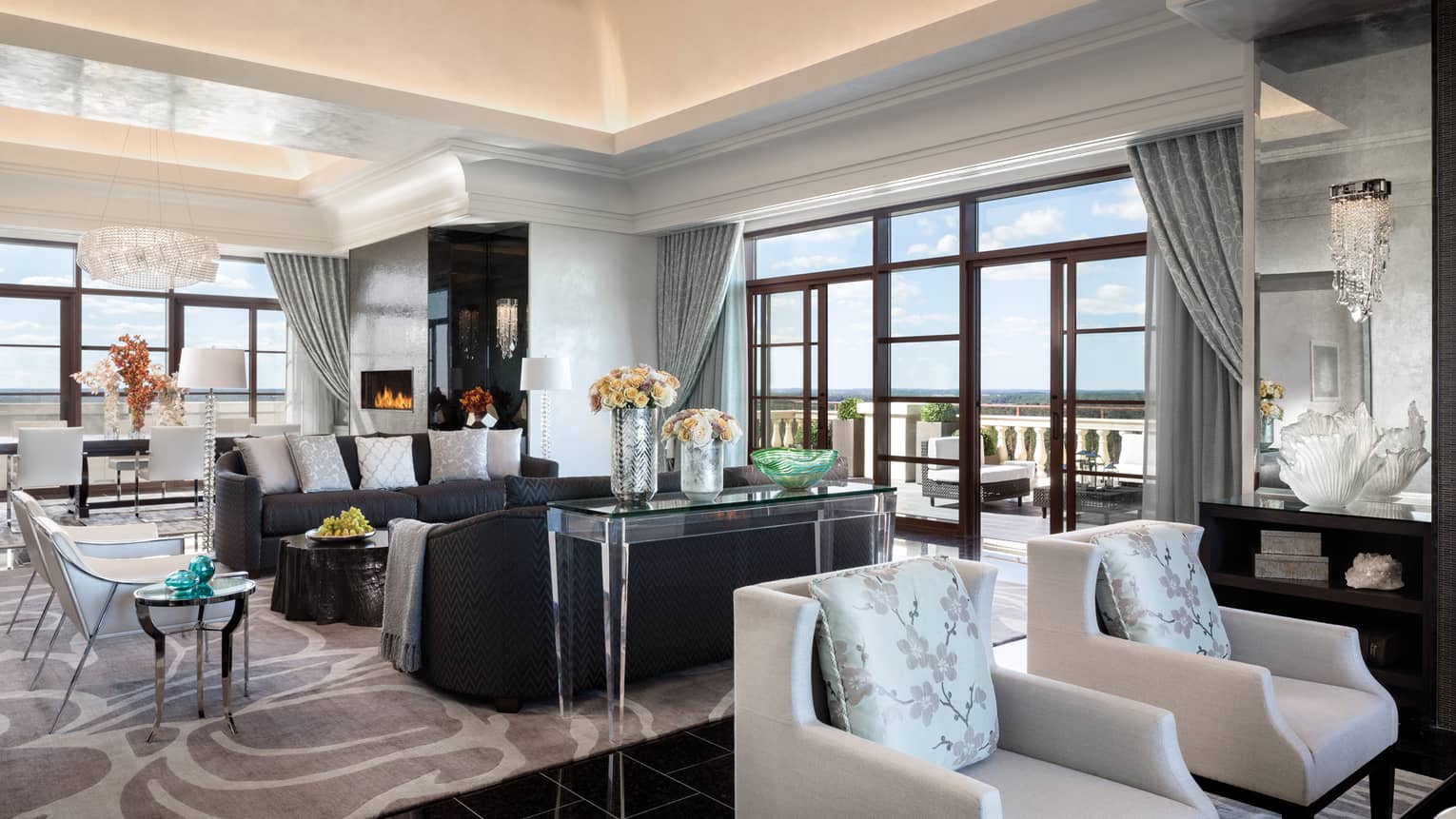 Royal Suite two seating areas in bright room under soaring ceilings, corner floor-to-ceiling windows