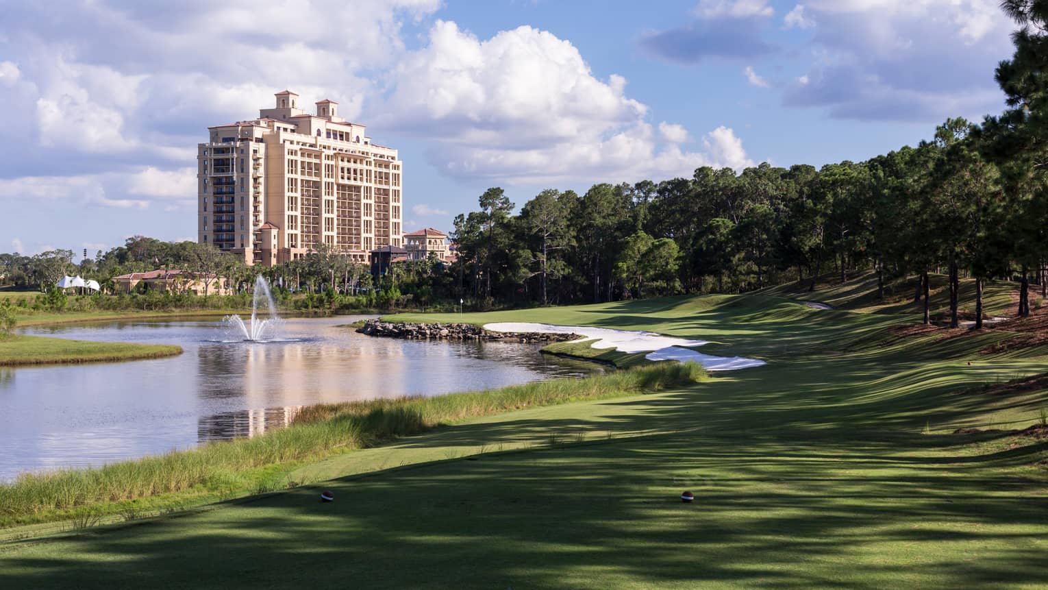 Tranquilo Golf Club fountain in river by greens, hotel building in background