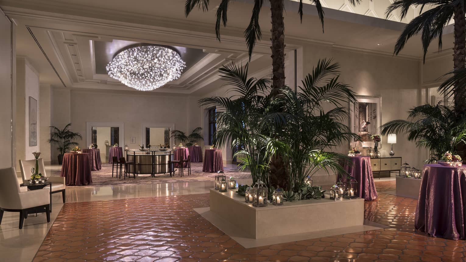 Grand Ballroom Foyer with potted palm trees and candles, cocktail lounge tables under light