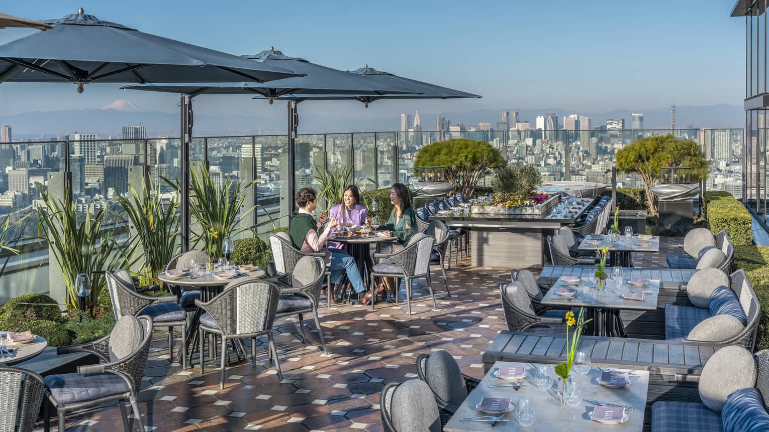 Group of three friends enjoy a meal on PIGNETO's open-air terrace
