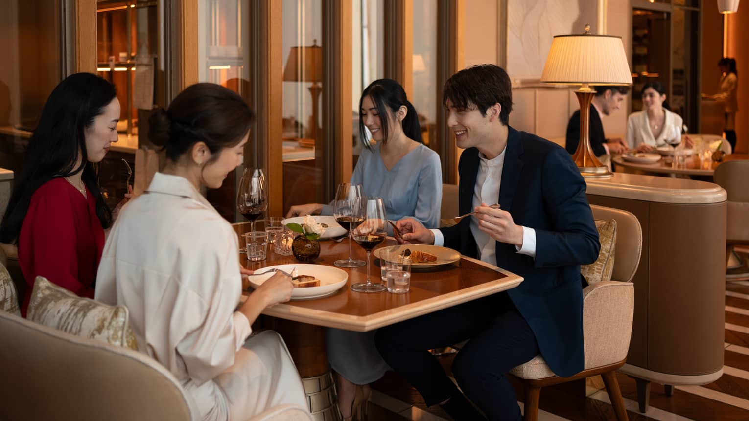 A group of friends eats at stylish restaurant table