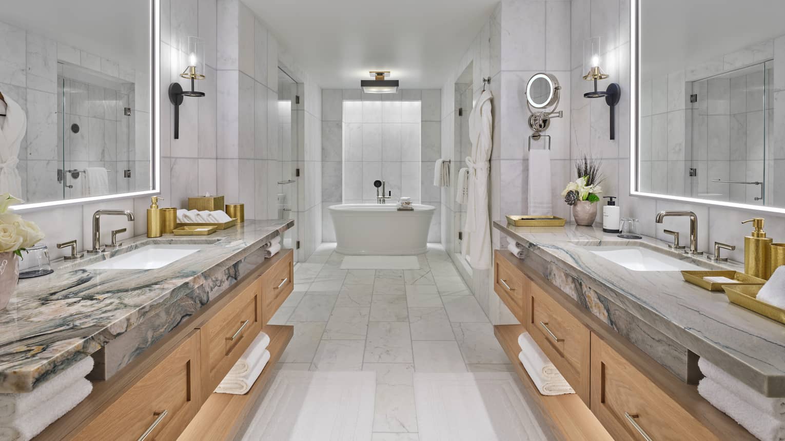 Large marble bathroom, with a vanity on each side and a standalone tub