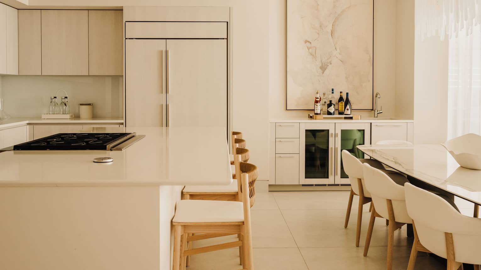 Luxury modern kitchen with counter seating at the island, and a dining table with eight chairs
