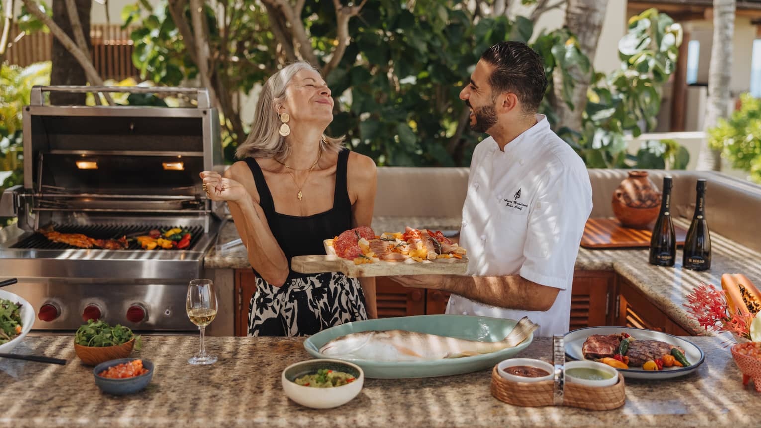 Private chef serving food to a smiling woman