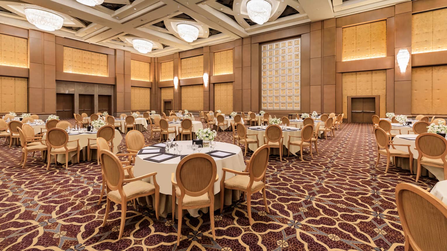 Banquet tables set for an event in a grand hotel ballroom