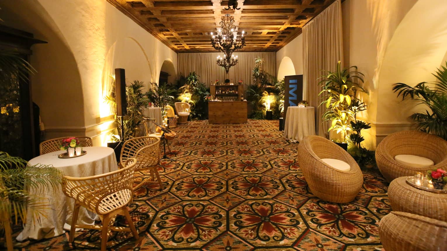 La Salita carpeted event room with wicker lounge furniture, small wood bar 