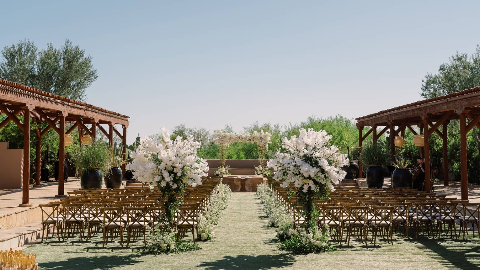 An outdoor wedding venue with two large bouquets of flowers