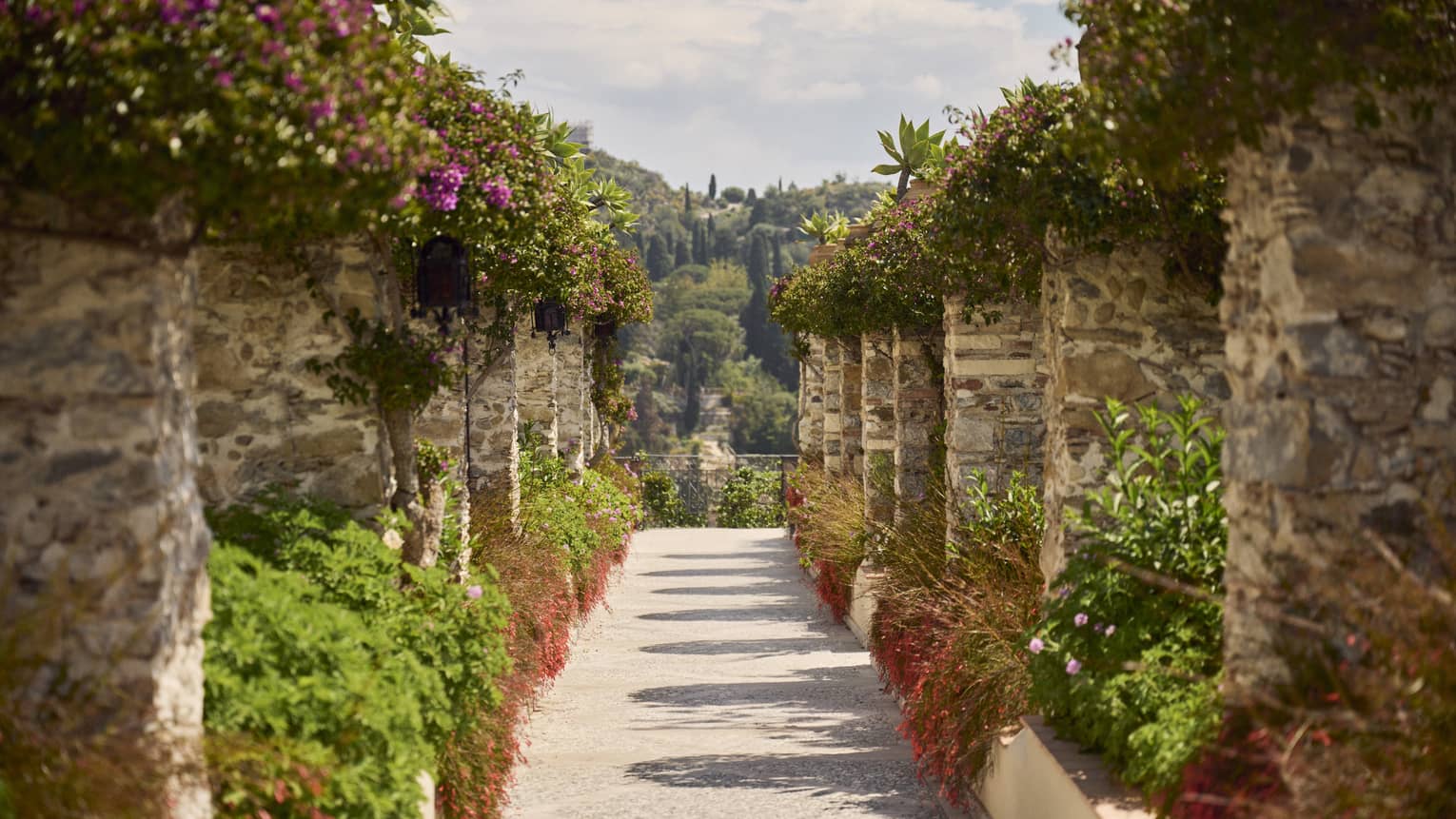 Garden walkway with stone columns topped with greenery