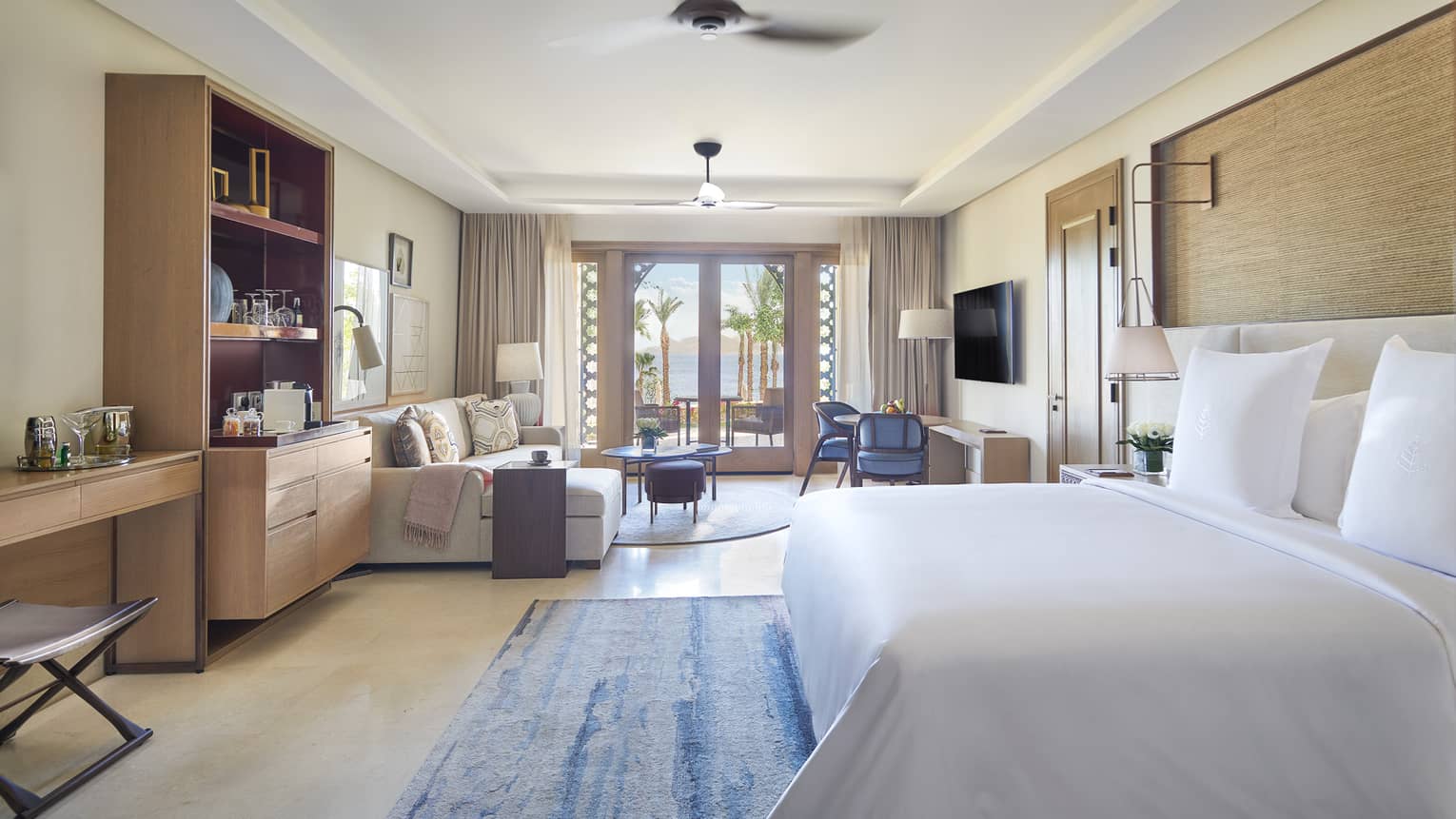 Bedroom with king bed, sitting area and glass doors to patio