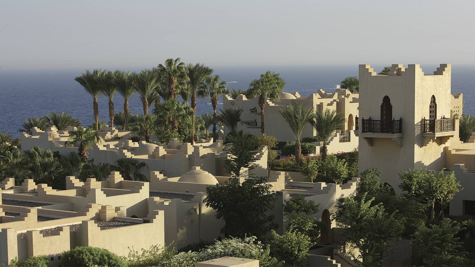 Aerial view over resort building and rooftops. palm trees