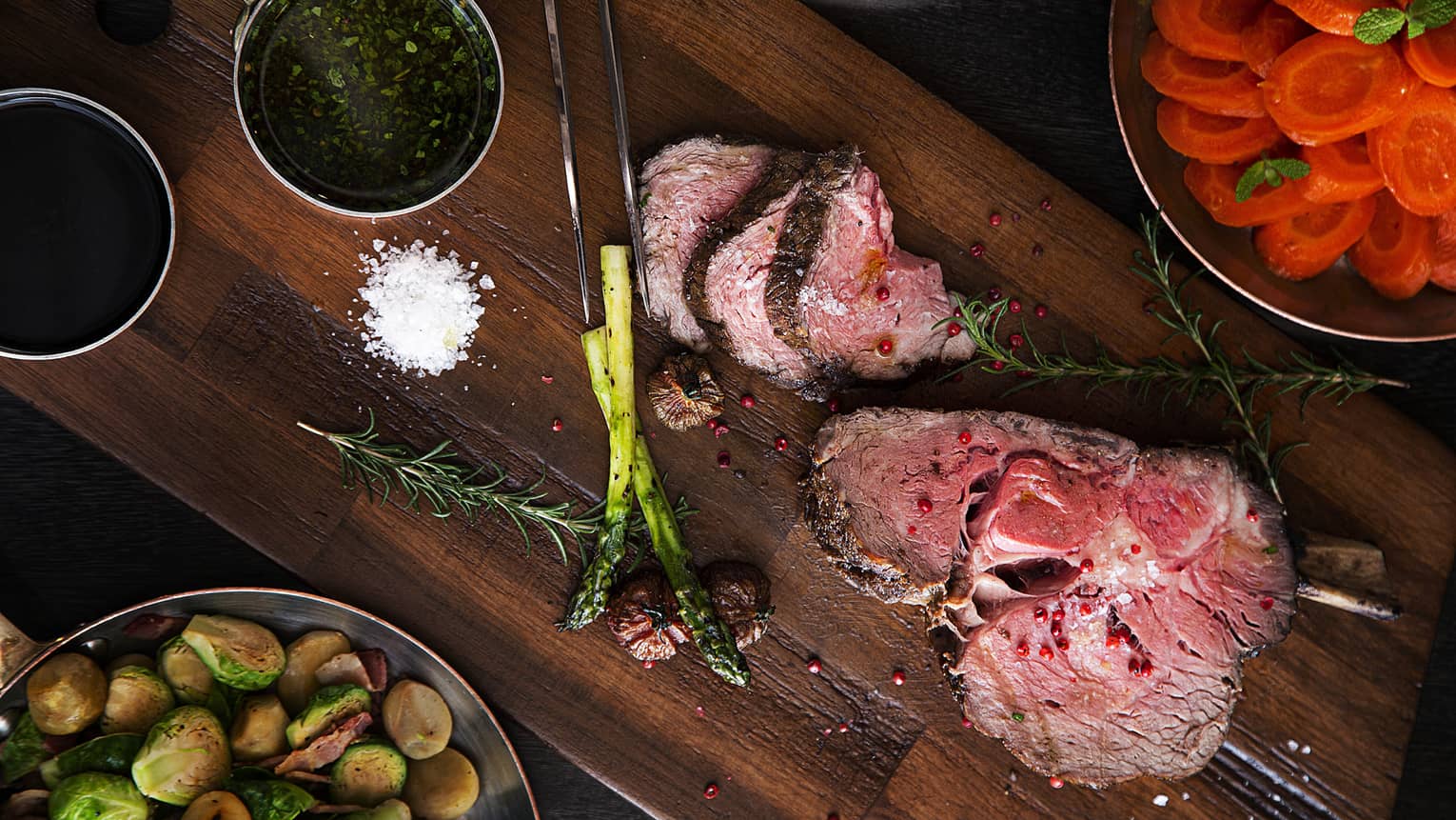 Sliced prime rib with chimichurri sauce, roasted Brussels, glazed carrots