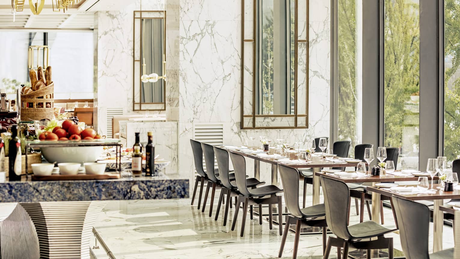 Sunny Boccalino dining room with white marble walls, buffet with apples, fresh breads