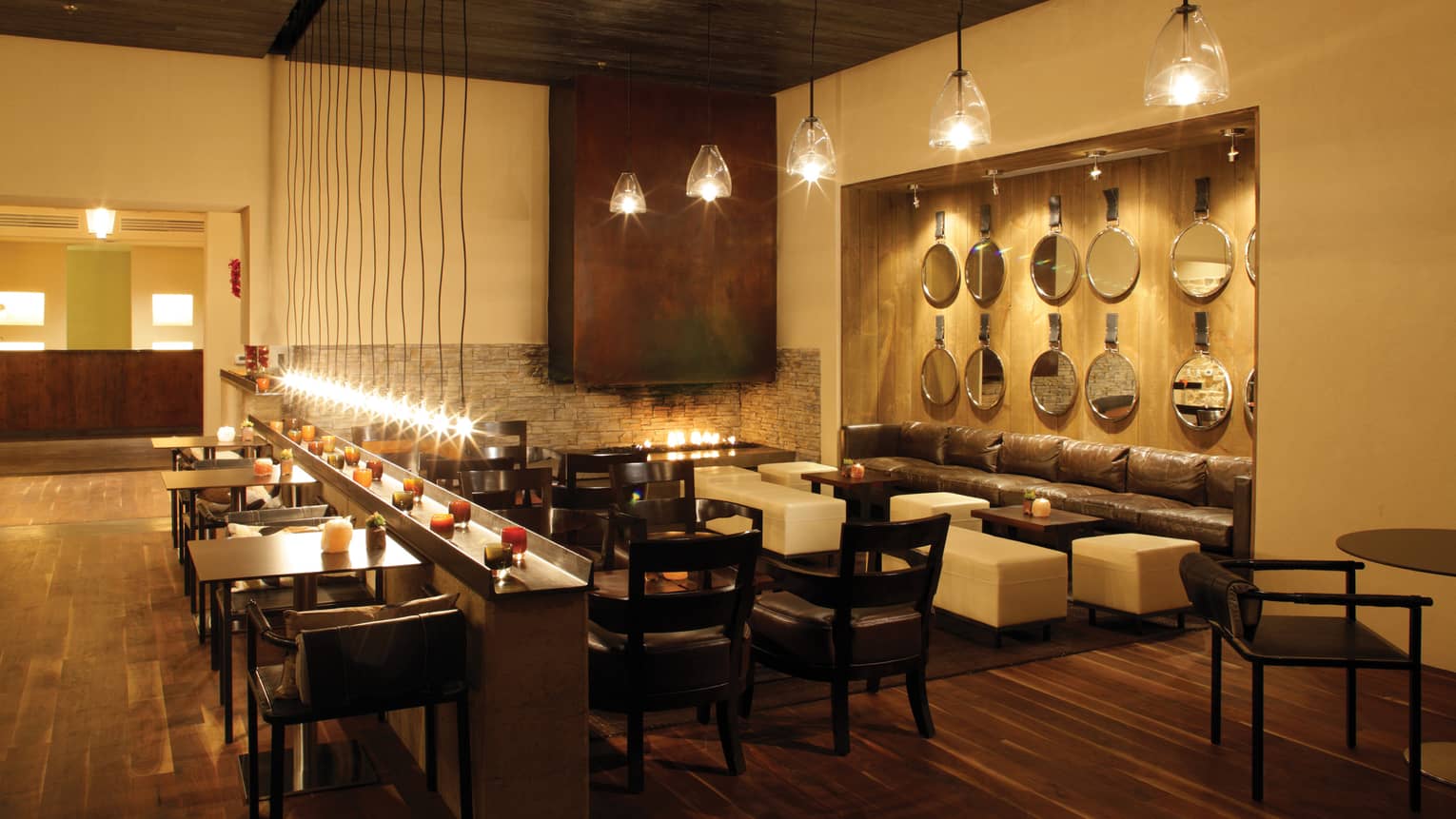 The Bar dimly-lit lounge, tables, sofas under hanging lights