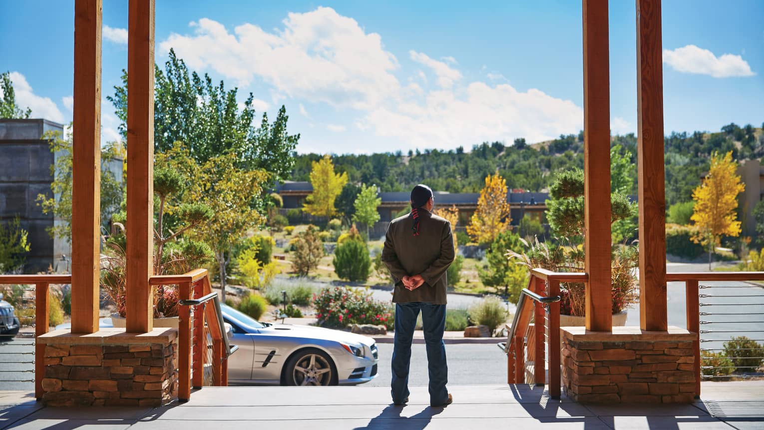 Back of man standing at top of Four Seasons Resort Santa Fe entrance, driveway