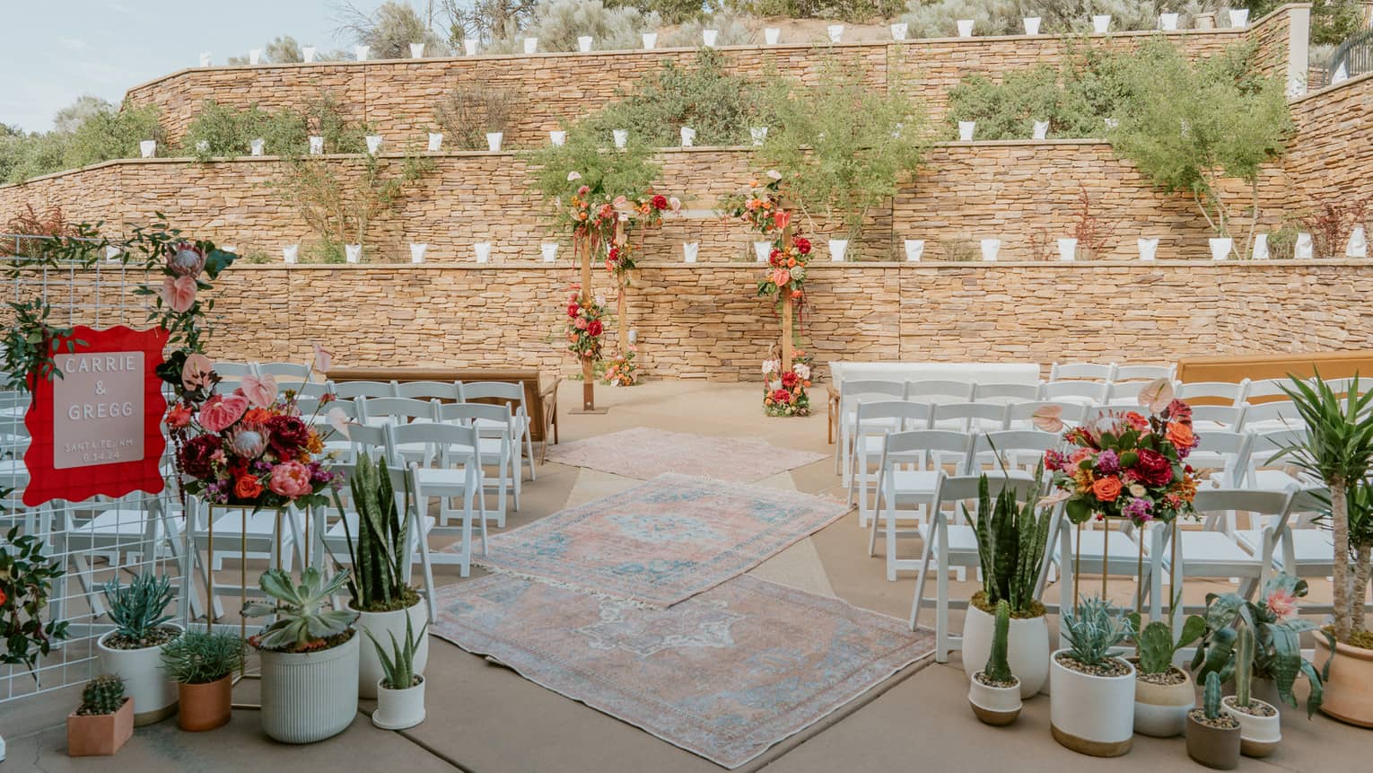 An outdoor space set up for a wedding with bouquets of flowers and rows of chairs